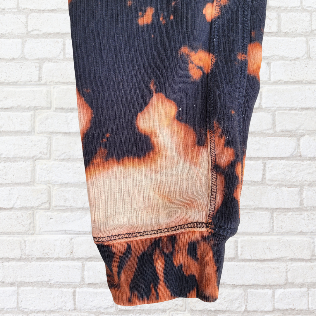 Close-up of a tie-dye pattern on fabric against a white brick wall background