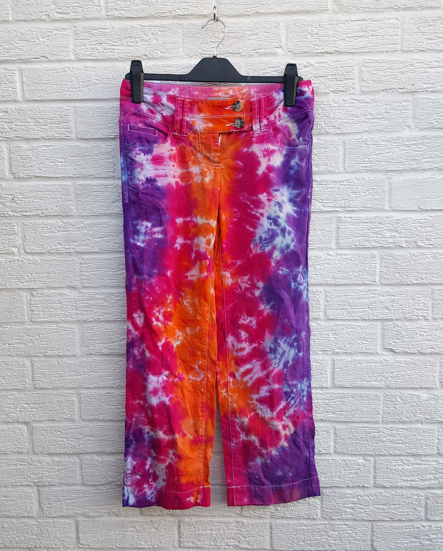 Tie dye trousers, in bright orange, pink and purple shades - perfect for the hippie at heart! In 100% Cotton to fit UK size 6R or US size 2. These trousers were thrifted and upcycled using cold water, eco reactive dyes, so they're not just unique, they're friendlier to the environment too. Hand dyed with love by AbiDashery. We only use recycled and compostable packaging!