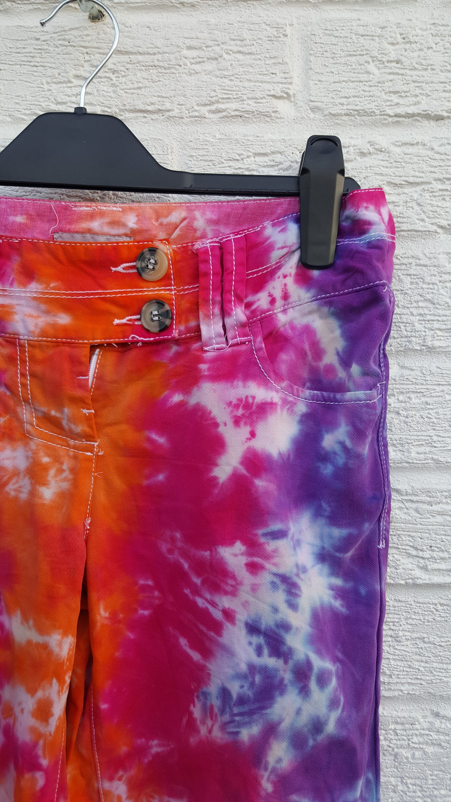 Tie dye trousers, in bright orange, pink and purple shades - perfect for the hippie at heart! In 100% Cotton to fit UK size 6R or US size 2. These trousers were thrifted and upcycled using cold water, eco reactive dyes, so they're not just unique, they're friendlier to the environment too. Hand dyed with love by AbiDashery. We only use recycled and compostable packaging!