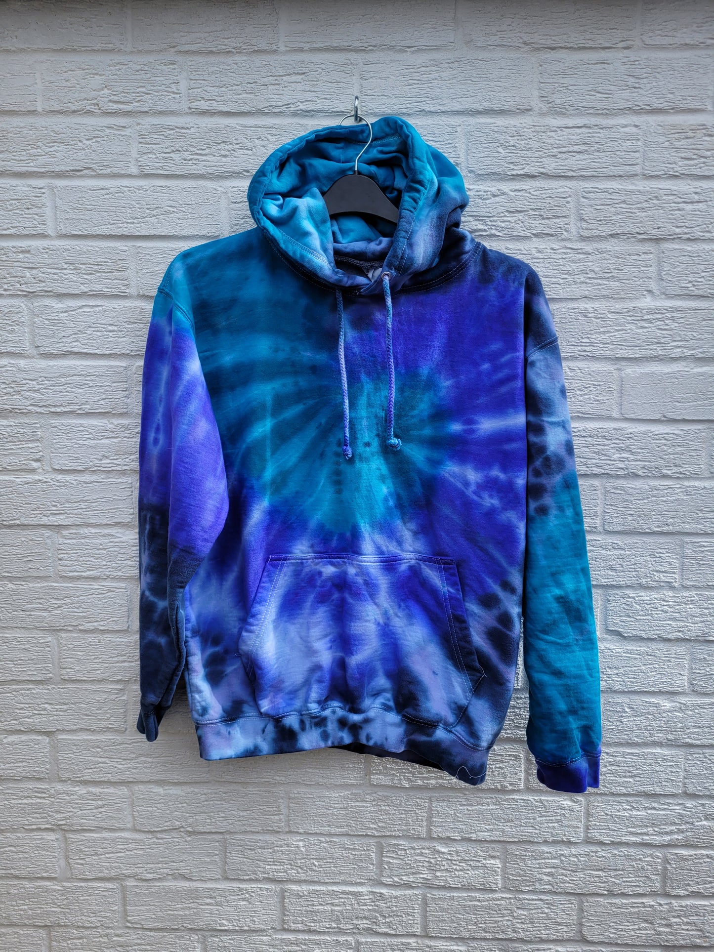 Organic cotton tie dye hoodie, in aqua, blue and navy shades, the perfect cosy cover up for the coming summer evenings.

These one of a kind hoodies are hand dyed to order, in 80% Organic Cotton, 20% Recycled Polyester, double fabric hood, front pouch pocket, ribbed cuffs and hem