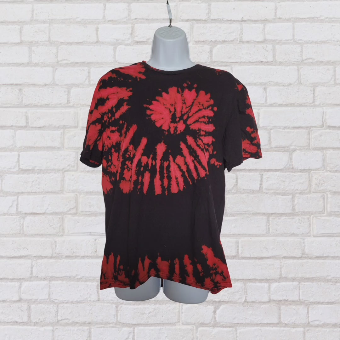 AbiDashery black and orange tie-dye t-shirt on a mannequin against a white wall — Sacral Chakra Collection
