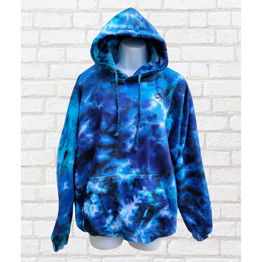 Blue tie-dye hoodie on a mannequin against a white brick wall.