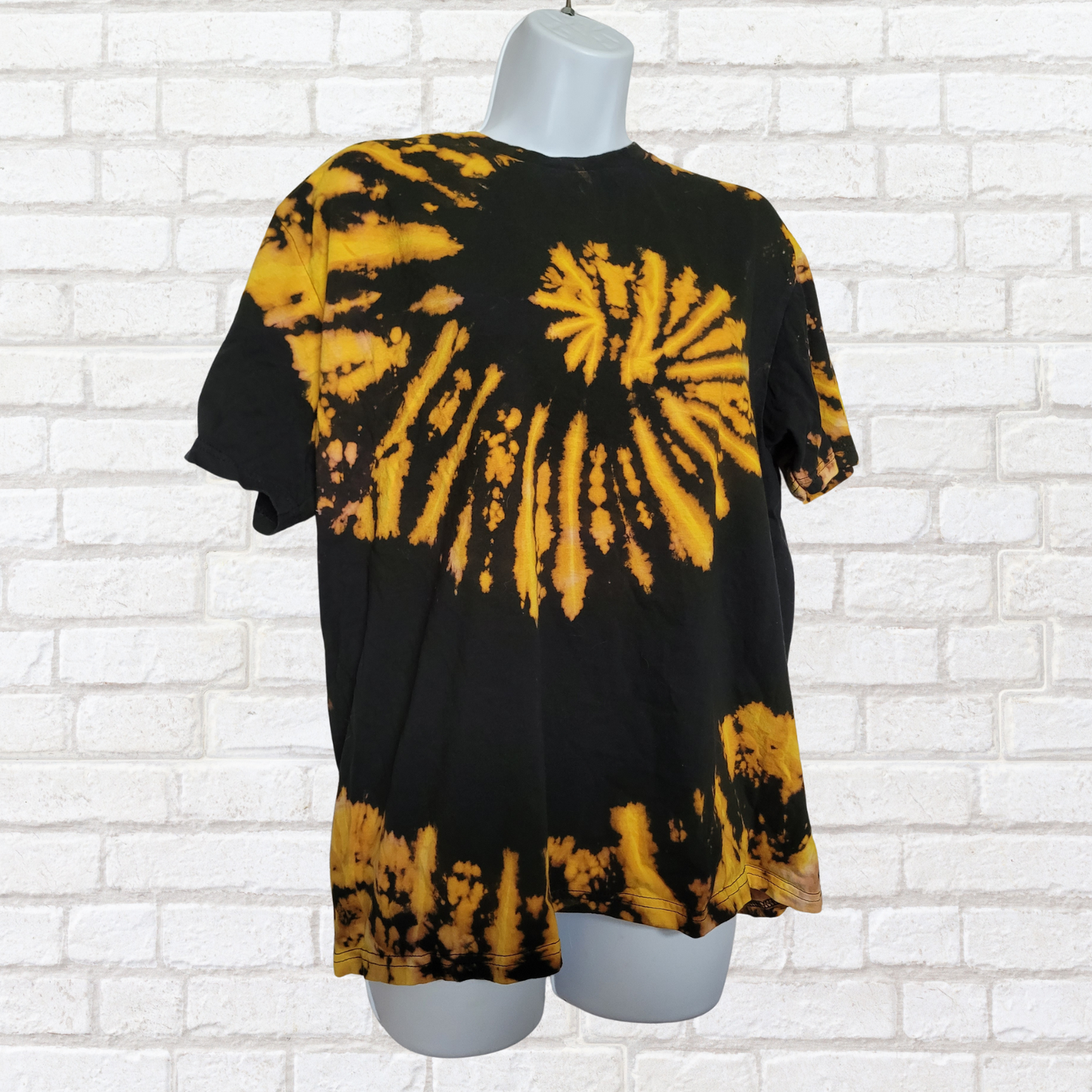 AbiDashery black and yellow tie-dye t-shirt on a mannequin against a white wall — Solar Plexus Chakra Collection
