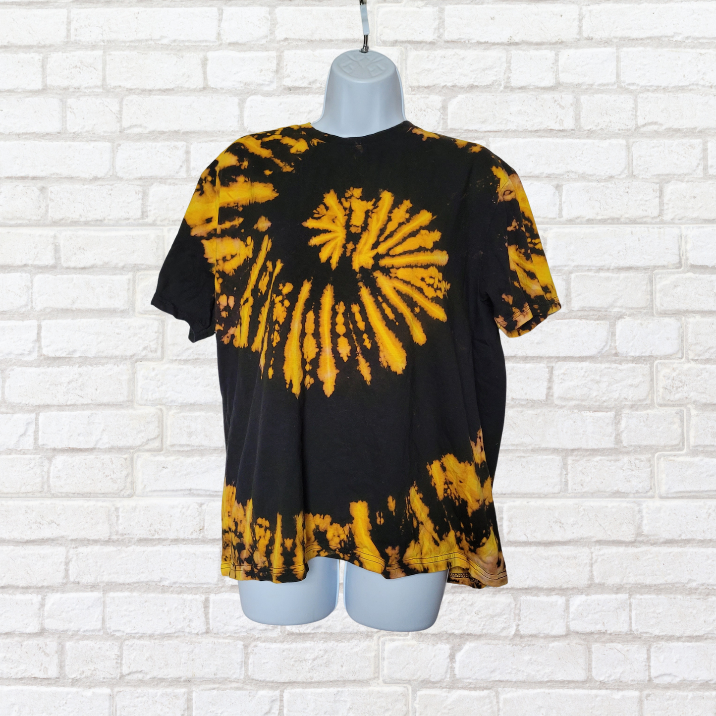 AbiDashery black and yellow tie-dye t-shirt on a mannequin against a white wall — Solar Plexus Chakra Collection
