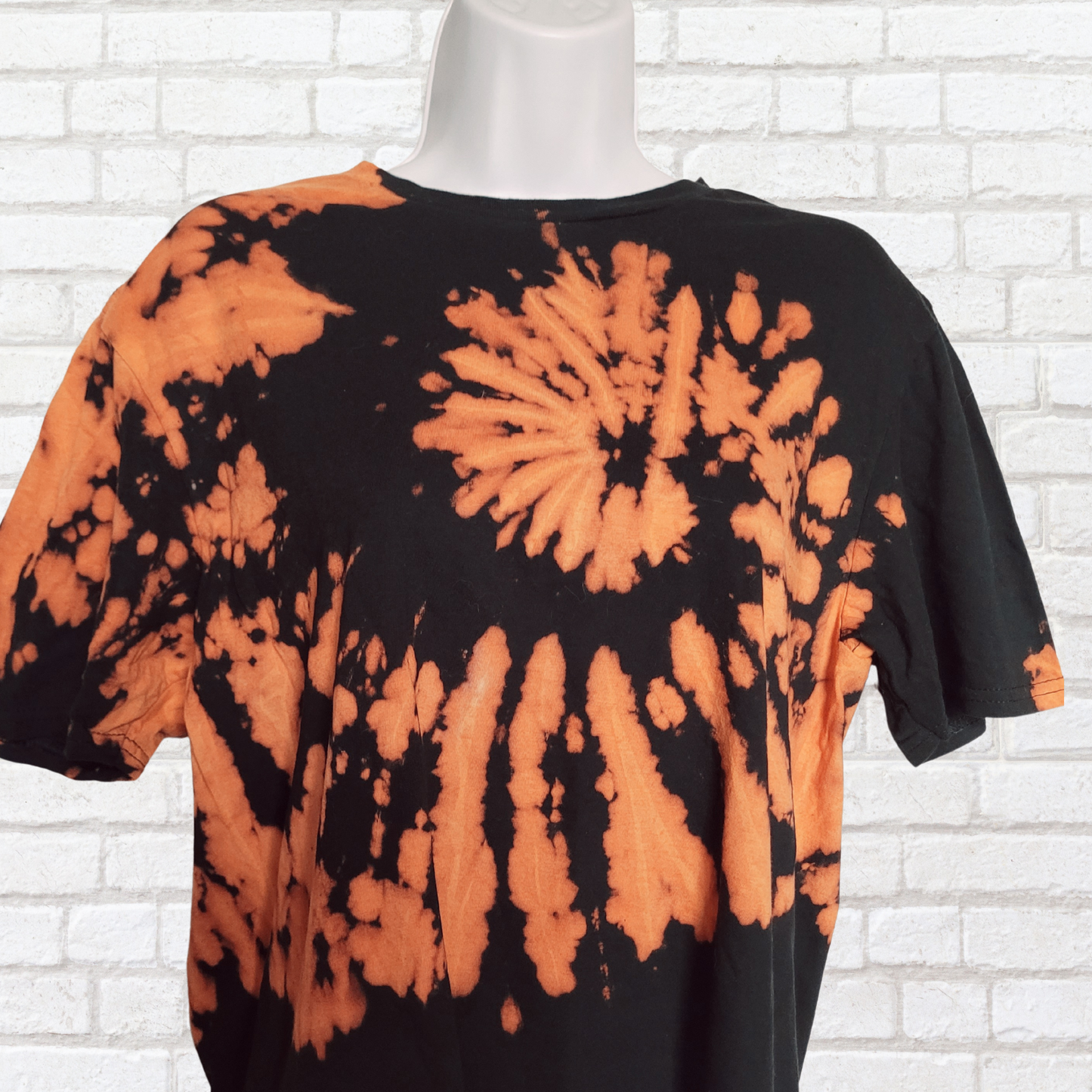 AbiDashery black and orange tie-dye t-shirt on a mannequin against a white wall — Sacral Chakra Collection
