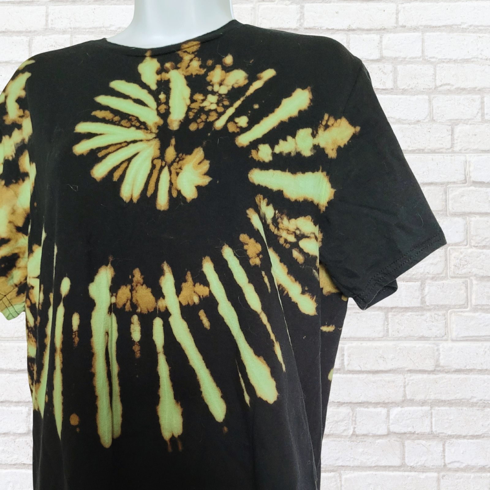 AbiDashery black and green tie-dye t-shirt on a mannequin against a white wall — Heart Chakra Collection
