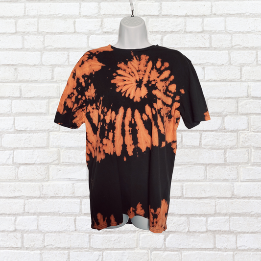 AbiDashery black and orange tie-dye t-shirt on a mannequin against a white wall — Sacral Chakra Collection
