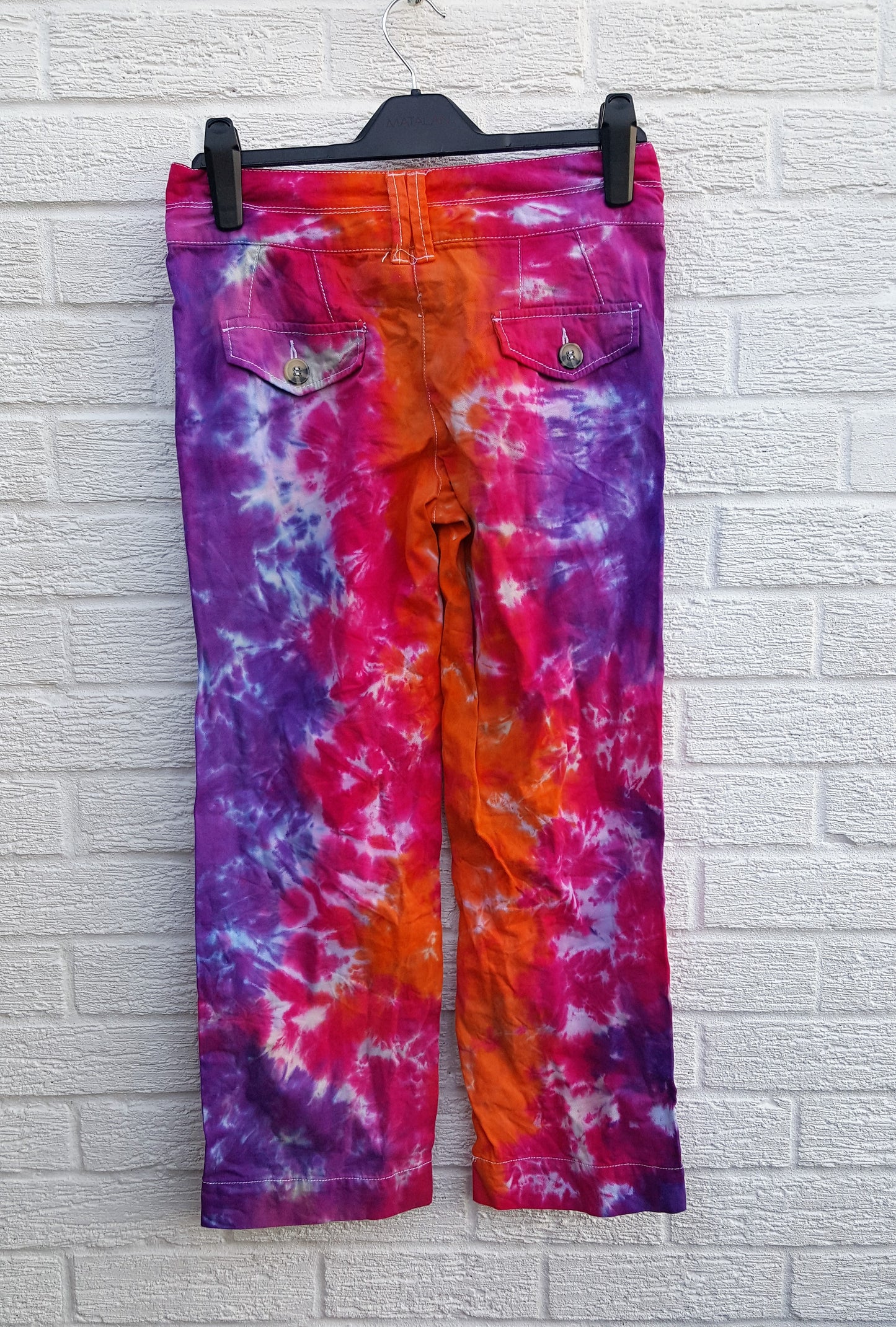 Tie dye trousers, in bright orange, pink and purple shades - perfect for the hippie at heart! In 100% Cotton to fit UK size 6R or US size 2.  These trousers were thrifted and upcycled using cold water, eco reactive dyes, so they're not just unique, they're friendlier to the environment too.  Hand dyed with love by AbiDashery.  We only use recycled and compostable packaging!